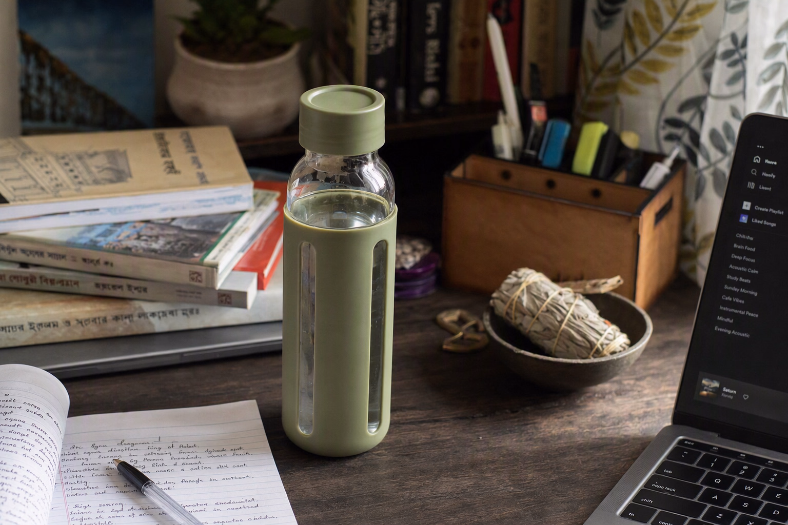 Jolora bottle beside notebooks on a Bangladesh study desk