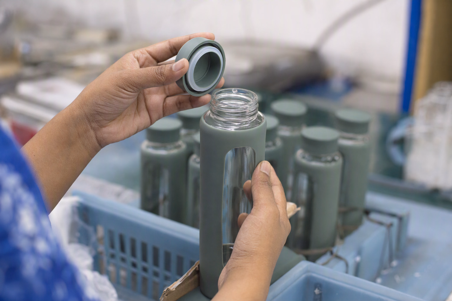 Hands visually inspecting the rim and lid of a glass bottle