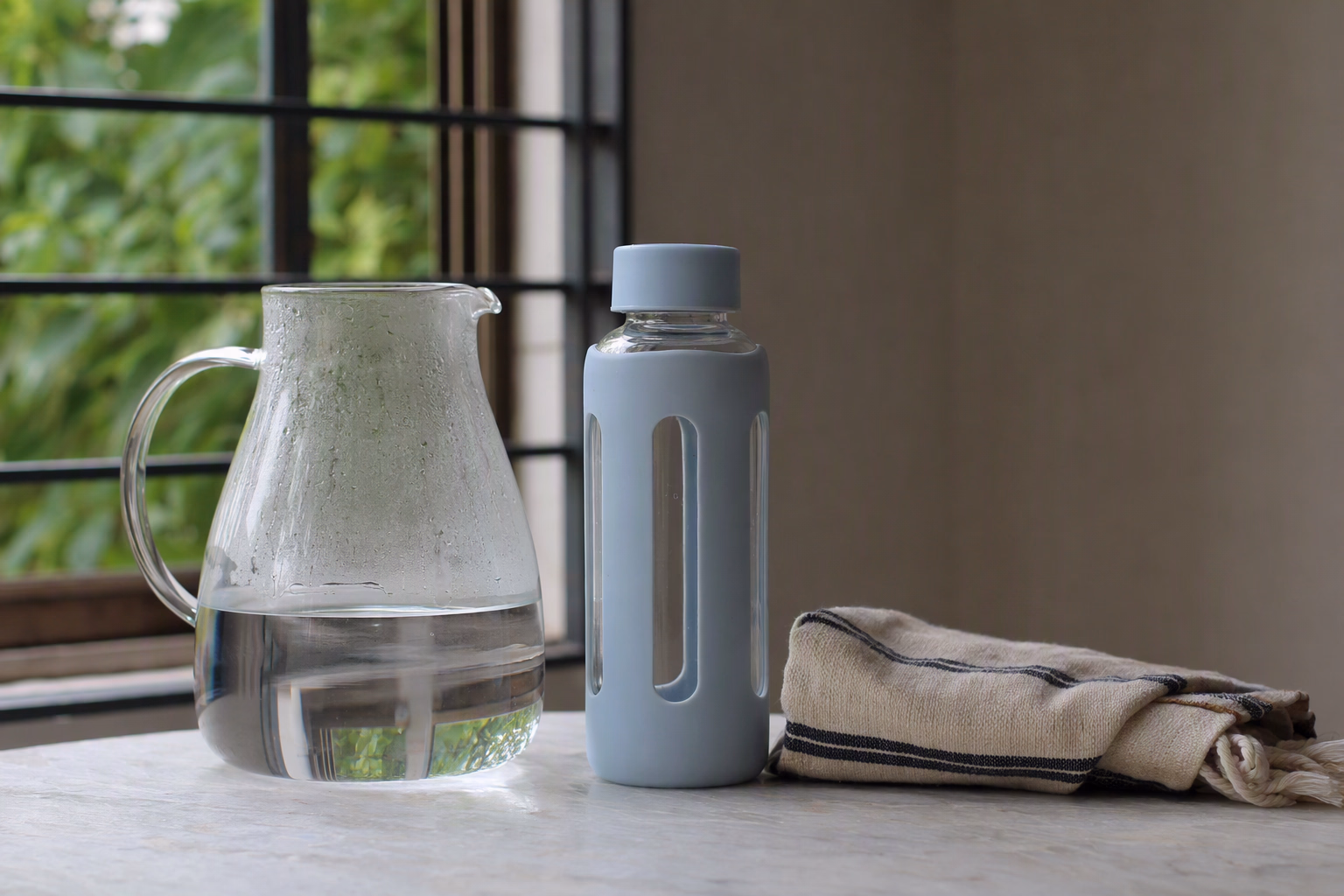 Glass bottle resting away from a hot kettle on a kitchen counter