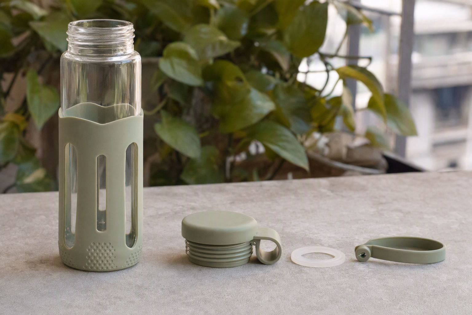 Jolora bottle components arranged separately: clear bottle, lid, gasket, sleeve, and carry loop