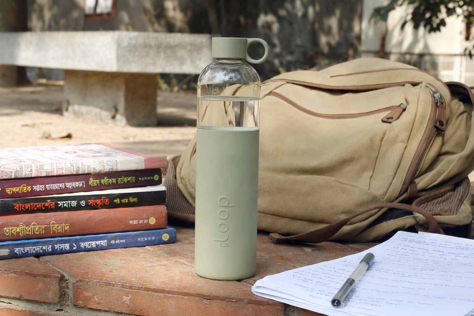 Compact Jolora bottle beside notebooks in a Bangladesh university setting