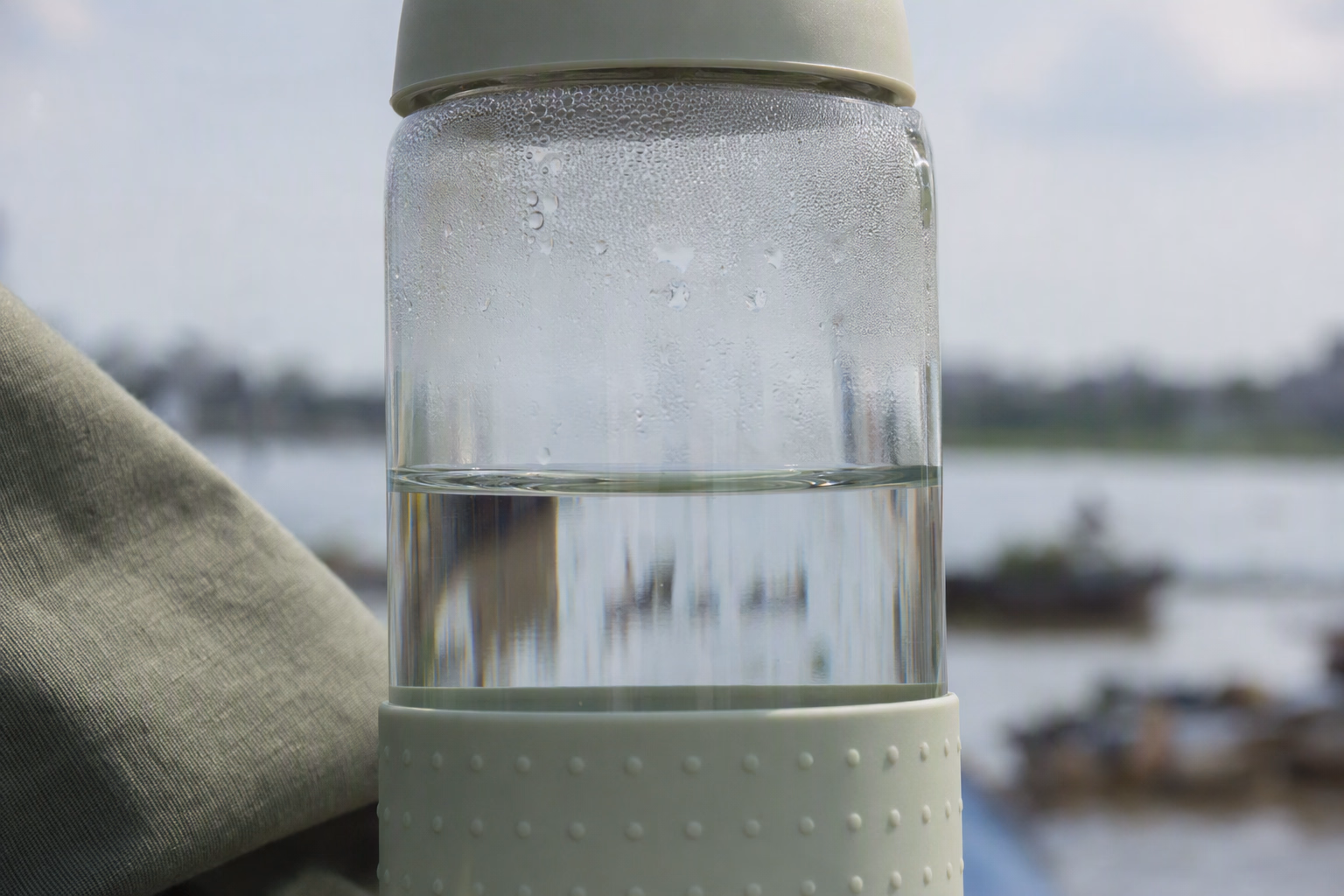 Macro view of clear water against the wall and rim of a glass bottle